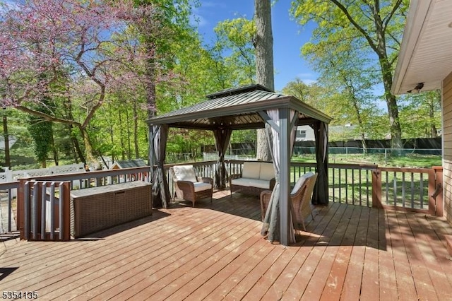 wooden terrace featuring a gazebo, outdoor lounge area, and a fenced backyard