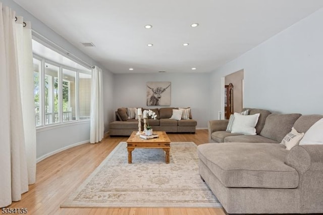 living room featuring baseboards, light wood finished floors, recessed lighting, and visible vents