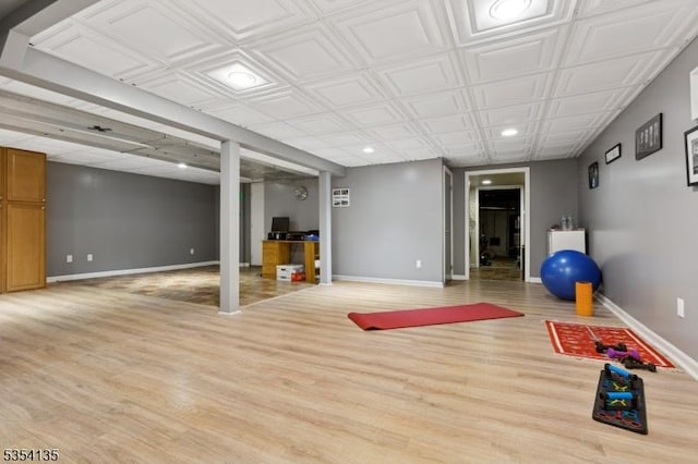 workout room with recessed lighting, baseboards, and light wood-type flooring