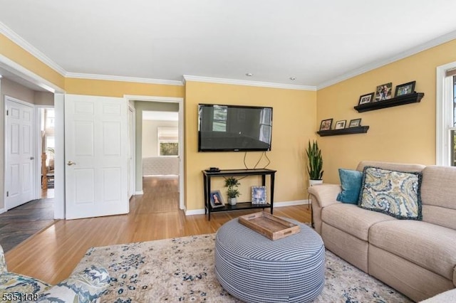 living room with crown molding, baseboards, and wood finished floors