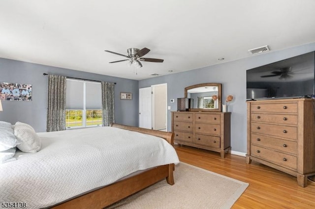 bedroom with light wood-type flooring, ceiling fan, and visible vents