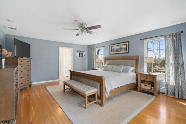 bedroom with visible vents, a ceiling fan, light wood-style flooring, and baseboards