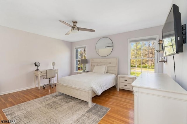 bedroom featuring multiple windows, a ceiling fan, and light wood finished floors