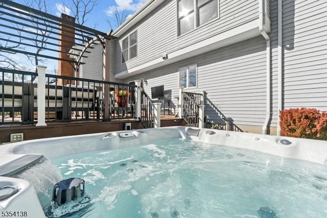 view of swimming pool featuring a wooden deck and a hot tub