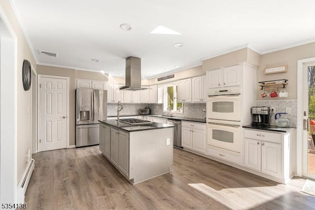 kitchen featuring crown molding, dark countertops, stainless steel appliances, decorative backsplash, and island exhaust hood