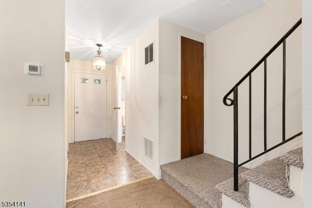 carpeted foyer entrance featuring visible vents