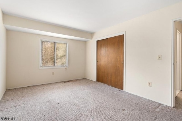 unfurnished bedroom with carpet and a closet