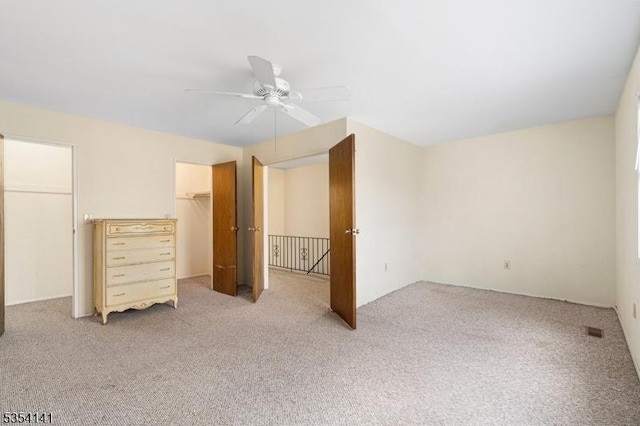 unfurnished bedroom with a ceiling fan, visible vents, and light carpet