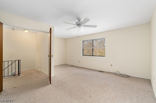 unfurnished room with a ceiling fan and carpet