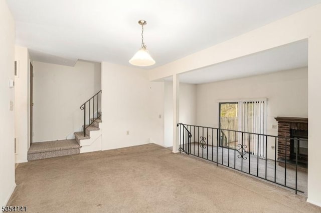 carpeted empty room with a fireplace