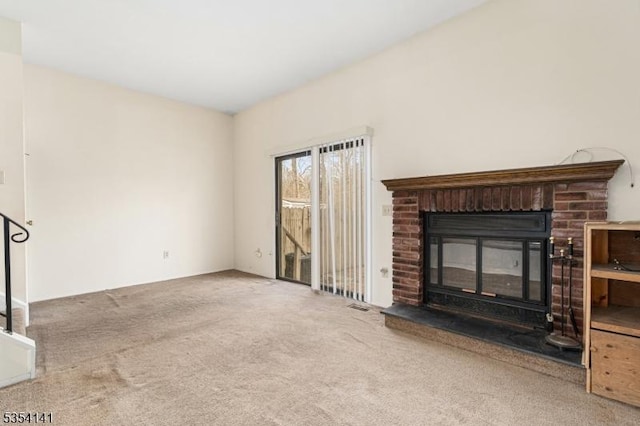 unfurnished living room with carpet, a fireplace, and visible vents