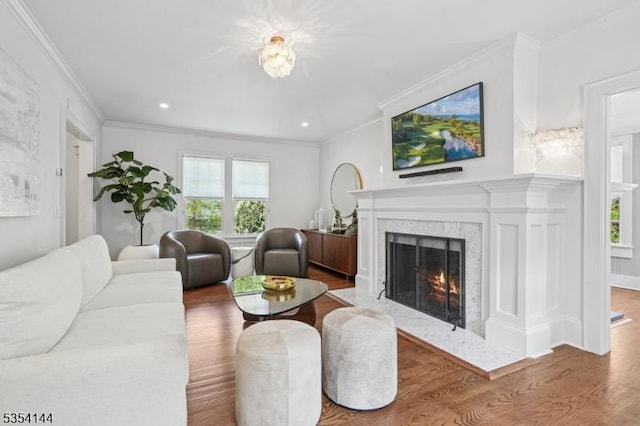 living area with ornamental molding, a fireplace, recessed lighting, and wood finished floors