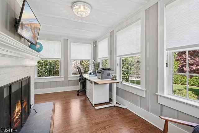 office space with a glass covered fireplace, baseboards, and dark wood-style flooring