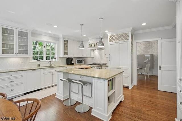 kitchen with crown molding, a center island, white cabinets, and stove
