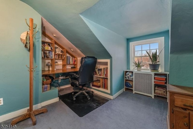 carpeted office space with baseboards and vaulted ceiling