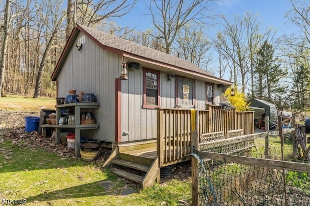 exterior space with a shingled roof and a front lawn