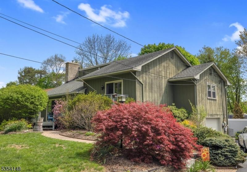 104 Lackawanna Dr, Byram Twp, NJ 07874 - view of side of home with roof with shingles, a chimney, and a yard