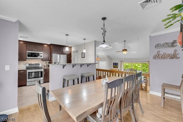 dining space with visible vents, light wood-style flooring, ceiling fan, and baseboards