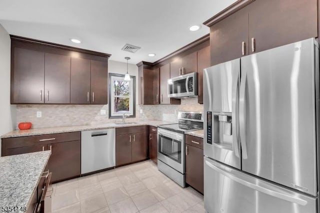 kitchen featuring dark brown cabinetry, appliances with stainless steel finishes, decorative backsplash, and visible vents