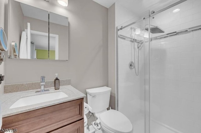 bathroom featuring vanity, toilet, and a stall shower