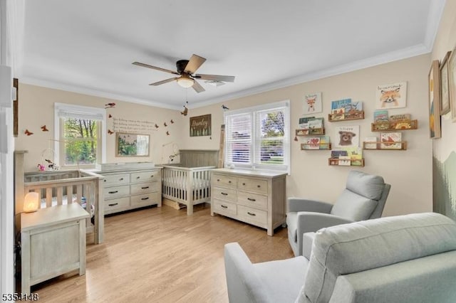 bedroom featuring multiple windows, ornamental molding, and light wood finished floors