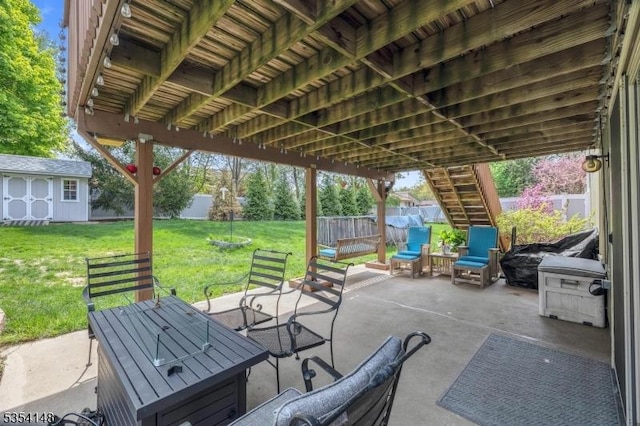 view of patio / terrace with a storage shed, a fenced backyard, an outbuilding, and stairway