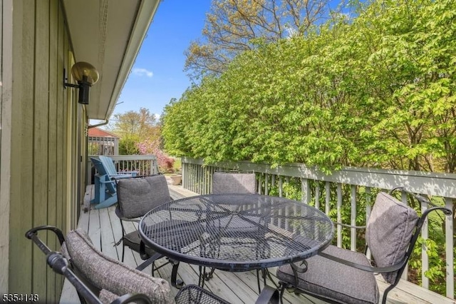 view of wooden balcony with outdoor dining space and a deck
