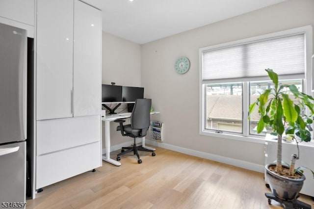 office space featuring baseboards, plenty of natural light, and light wood-style flooring