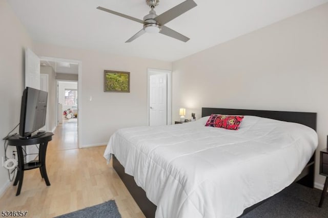 bedroom featuring baseboards, ceiling fan, and light wood-style floors