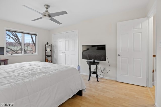 bedroom featuring a closet, a ceiling fan, light wood-style flooring, and baseboards