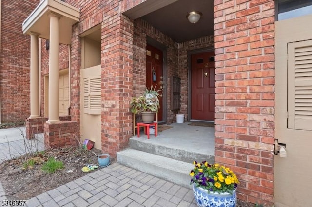 entrance to property featuring brick siding