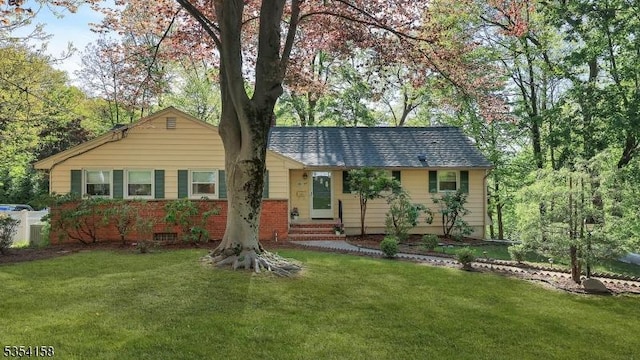 ranch-style house featuring entry steps and a front lawn