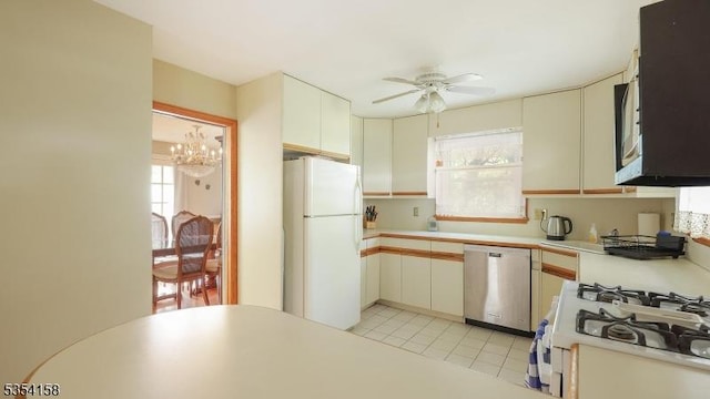 kitchen with white appliances, plenty of natural light, ceiling fan with notable chandelier, and light countertops