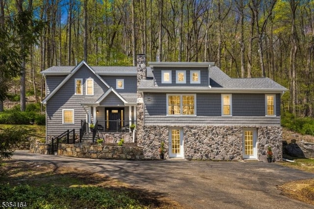 26 Woodland Rd, Mendham Twp, NJ 07960 - shingle-style home with stone siding, a chimney, driveway, covered porch, and a shingled roof