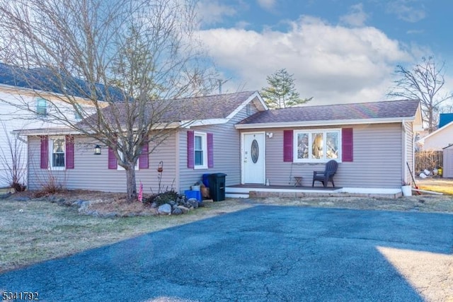 ranch-style house featuring roof with shingles