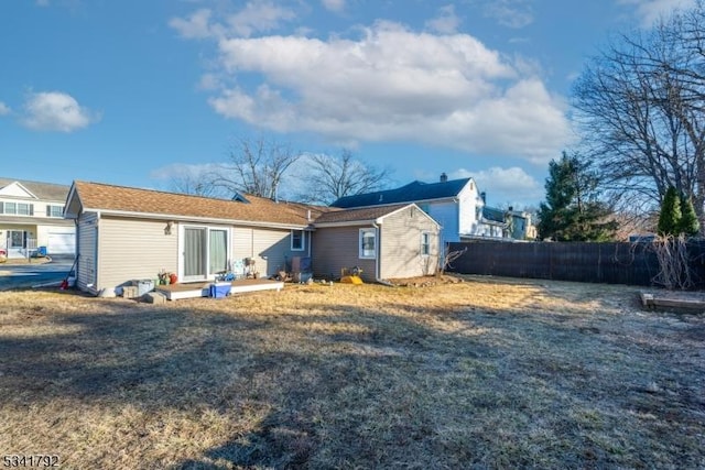 rear view of property with a lawn and fence