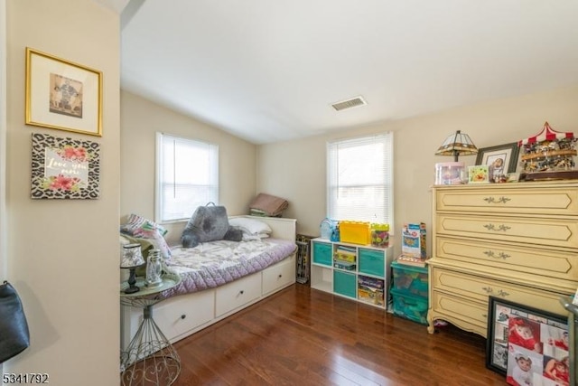 bedroom featuring visible vents, wood finished floors, and vaulted ceiling