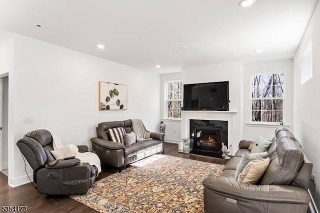 living room with a fireplace with flush hearth, recessed lighting, baseboards, and dark wood finished floors