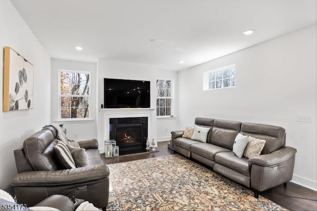 living room featuring a glass covered fireplace, recessed lighting, and dark wood-style floors