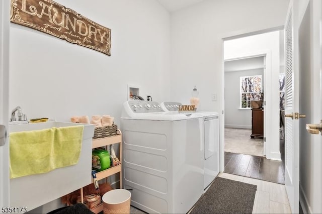 laundry room with a sink, separate washer and dryer, and laundry area