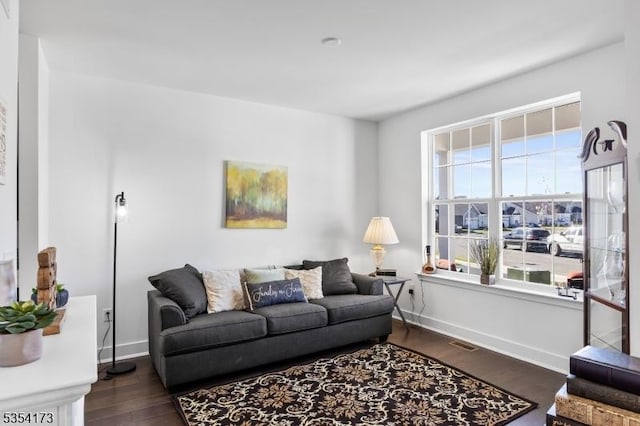 living room featuring baseboards, visible vents, and dark wood-type flooring