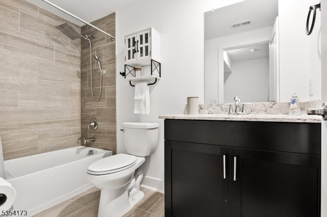 bathroom with vanity, toilet, baseboards, wood finished floors, and visible vents