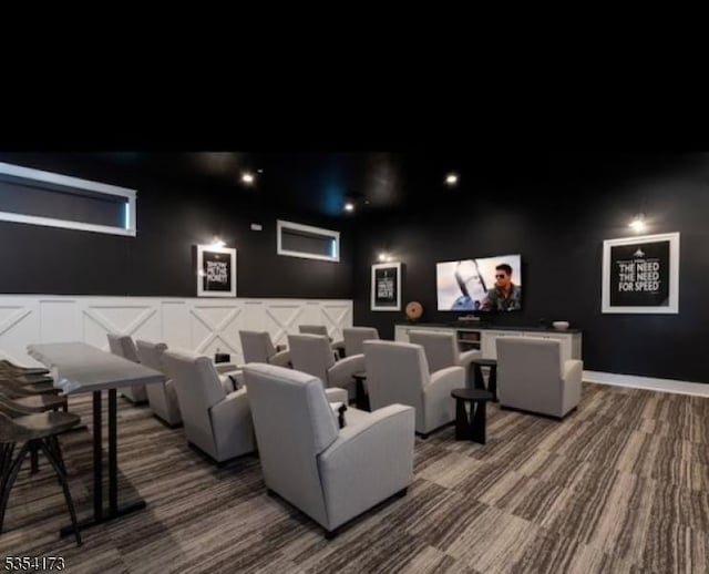 home theater room featuring carpet floors and a decorative wall
