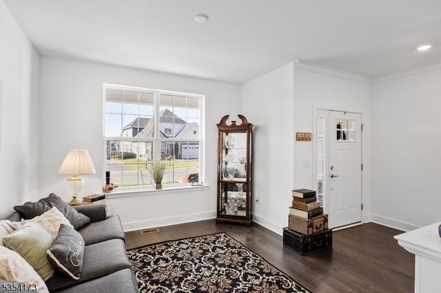 living area featuring crown molding, baseboards, and dark wood-style floors