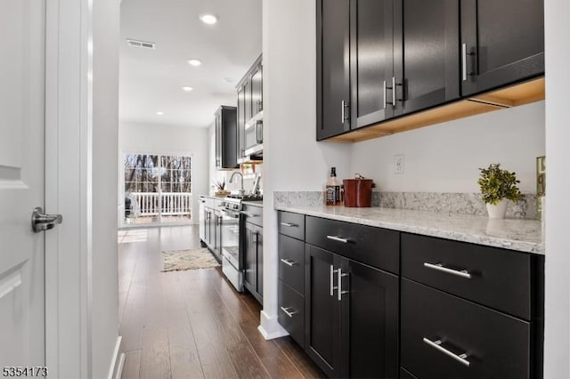 bar with visible vents, recessed lighting, dark wood finished floors, and stainless steel gas range