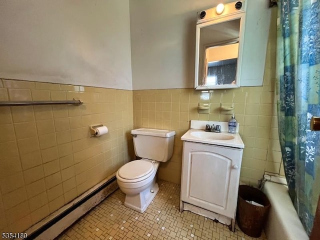 full bath featuring tile walls, tile patterned flooring, wainscoting, vanity, and toilet