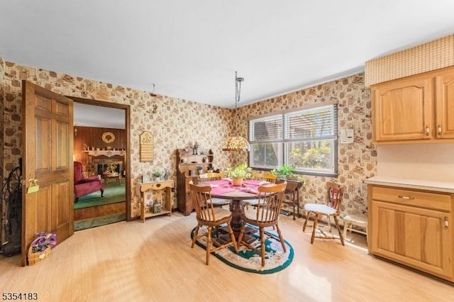 dining room with light wood-style flooring and wallpapered walls