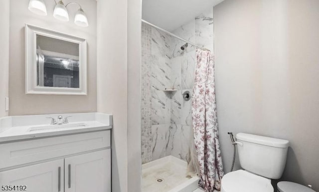 bathroom with vanity, toilet, and a shower stall