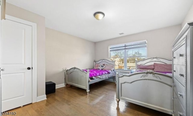 bedroom featuring baseboards and wood finished floors