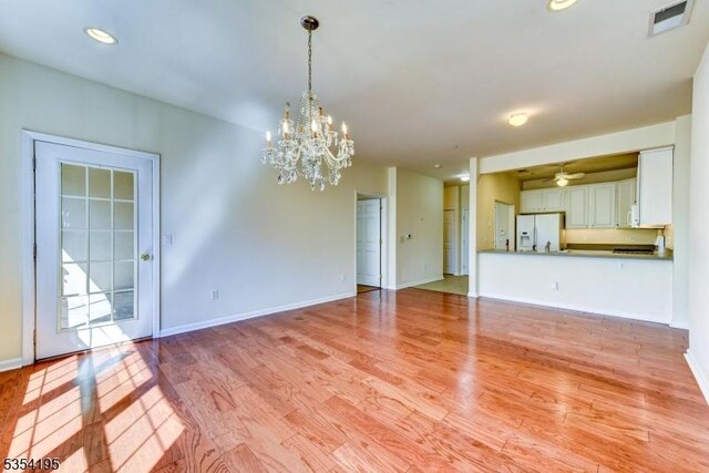 1310 Hamilton Dr, Rockaway Twp, NJ 07866 - unfurnished living room featuring baseboards, a chandelier, light wood-style flooring, and visible vents